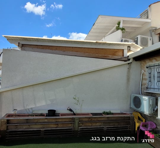 גג עם מזגנים, צמחייה ומעקה מתכת